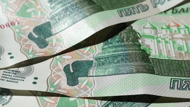 Money is scattered on the surface. Close-up of denominations of five Russian rubles