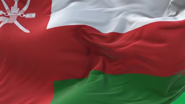 Waving flag of oman on a flagpole against a green background