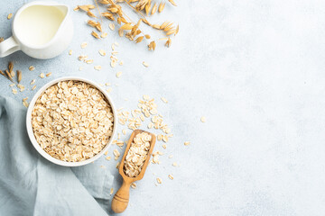 Naklejka premium Rolled oats flakes in a wooden bowl with ears.