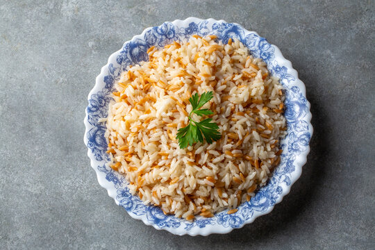 Traditional Turkish style rice pilaf with orzo garnished with a fresh parsley leaf served