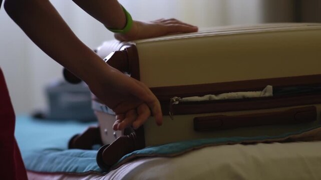A teenager is about to leave the hotel after a vacation with his family in a warm country. He packs and closes his suitcase. High quality FullHD footage