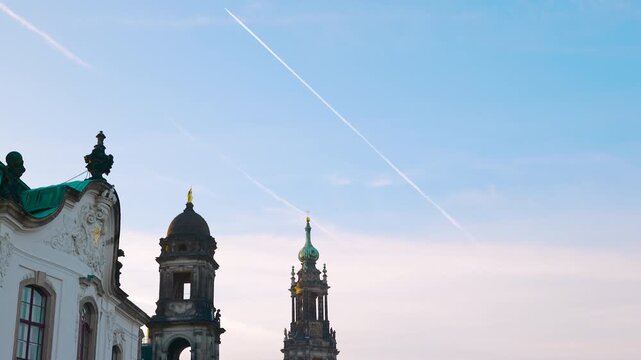 Dresden cathedral and historic buildings appearing from behind a rooftop. Historic dresden cathedral, also known as the cathedral of the holy trinity, gradually appearing in the city skyline