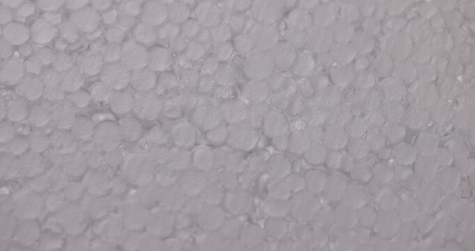 A fault in the white foam, a porous foam made of small round polystyrene balls has an uneven break line on the surface of the sheet.