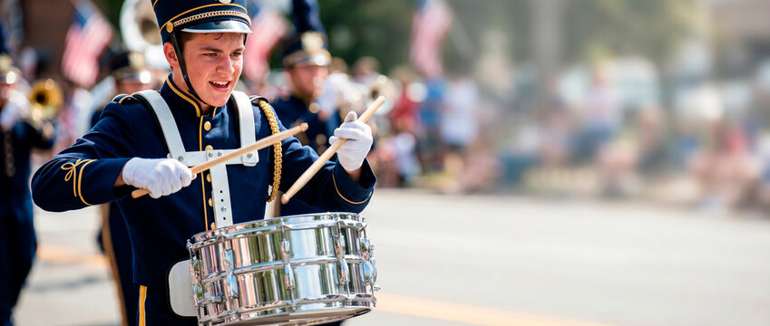 Drummer in marching band playing snare drum at Independence Day parade. Teen boy musician wearing uniform performing outdoors during patriotic American celebration on Fourth of July.