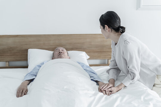 寝たきりの高齢者を看病する女性