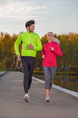 Fototapeta premium City Running Couple Happily Jogging Outside as Runners Training Outdoors Working Out in City As Fitness and Jogging Concepts.