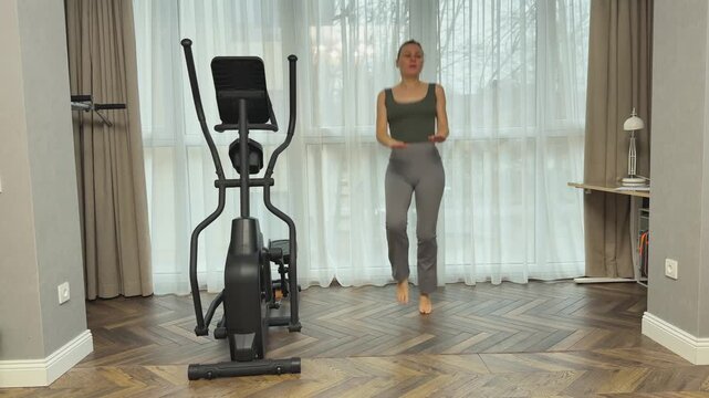 Athlete performs jumps bringing knees up to palms held in front. Dynamic home cardio exercise for coordination, endurance and strength.