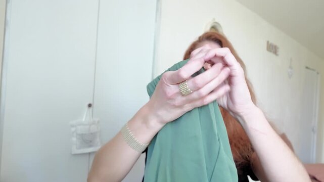 Dissatisfied woman pointing at loose thread on clothing, garment quality control and consumer complaint
