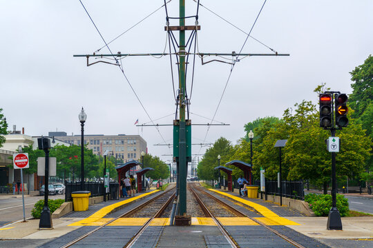 Symmetrical view of Boston light rail station with tracks, overhead wires, and center catenary pole

