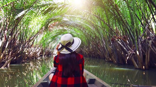 Asian woman Take a boat tour to see the Nipa palm tunnels in southern Thailand.