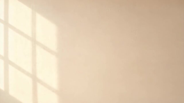 Sunlight casting window shadow on beige wall. Minimalist interior background with natural light pattern. Abstract architectural texture for design and composition