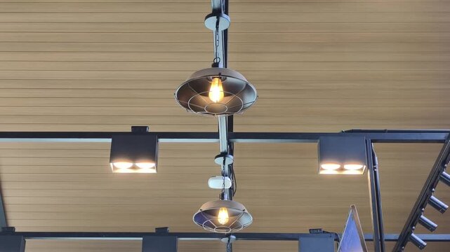 Industrial style light fixtures hanging from a wooden ceiling
