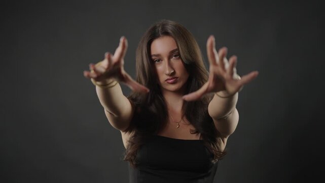 Female beauty and skincare concept with a young woman with long, flowing hair posing confidently in a studio setting. Fashion, cosmetics, and wellness advertising campaigns. The model s natural expres