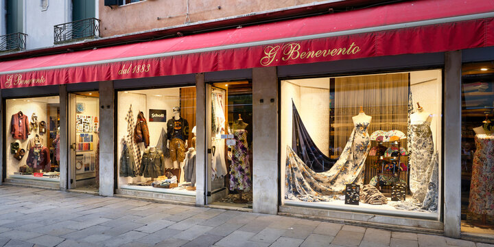 Venice, Italy June 01 2026: Storefront of the historic G. Benevento textile and clothing boutique in Venice, established in 1883, with elegant window displays.