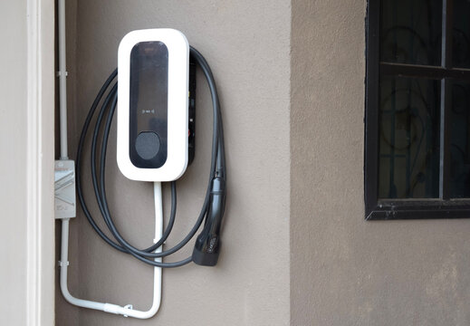 Electric Vehicle Charging Station Mounted on Exterior House Wall Close Up