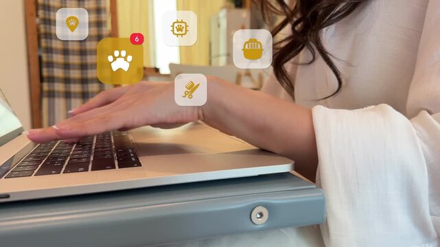 An East Asian woman uses her laptop computer at home to find pet care data, with virtual animal paw prints, microchip tracking, grooming, and pet GPS icons appearing.