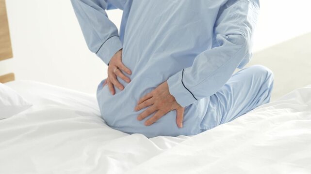 腰痛に悩む高齢者の男性の背中