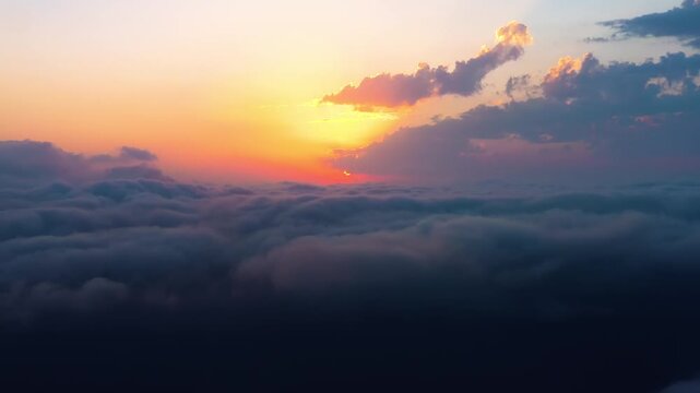 Stunning aerial view of sunrise over a dense layer of fluffy clouds in the early morning sky.