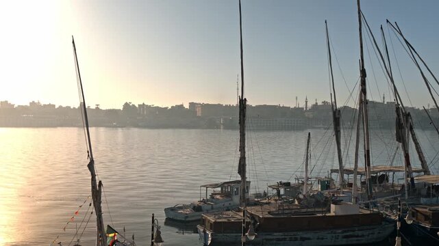 A scenic morning view looking across the calm waters of the Nile River in Luxor, Egypt.