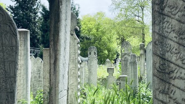 Ancient ottoman tombstones with engraved Quran verses and arabic calligraphy at historic Eyup Sultan Cemetery in Istanbul. Holy islamic scripture, sacred graveyard monuments and cultural heritage.