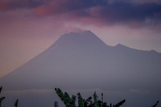The active volcano Merapi billows smoke over the lush green landscape
