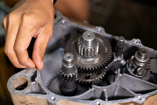 Mechanic hand gear metal machinery repair maintenance engineering industrial workshop Mechanic hand adjusting metal gear machinery, showing detailed engineering and maintenance process industrial