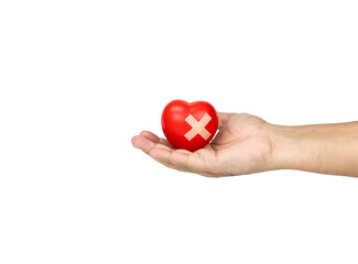 Obraz premium Hand holding red heart with adhesive bandage on white background.
