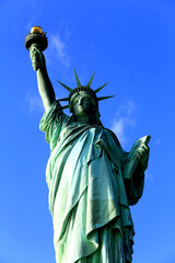 Fototapeta premium Vertical Low-Angle Shot of the Statue of Liberty Under Intense Blue Sky in New York City