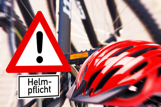 Fahrrad, ein roter Fahrradhelm und Verkehrsschild Helmpflicht