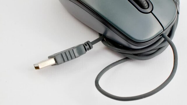 Gray computer mouse highlighted on a light surface, a symbol of productivity and technology. Detail of a gray computer mouse on a light background, ideal for work and innovation concepts.