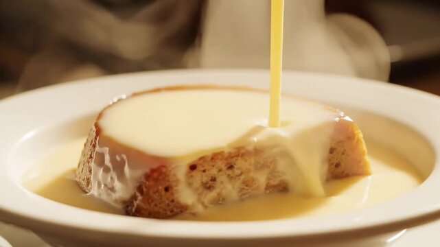 Detailed Close Up Of Rich Custard Sauce Being Poured Over Steaming Hot Traditional Malva Pudding In Close Up Shot South African Dessert Commercial