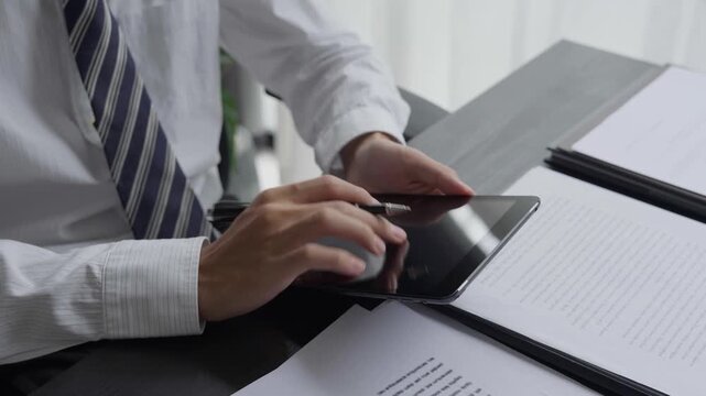 Lawyer using tablet checking legal document in office room