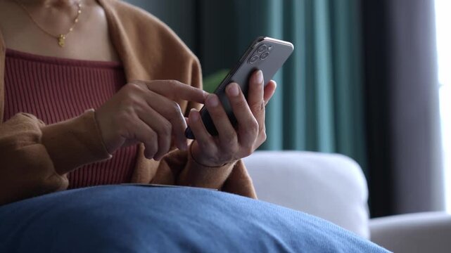 Asian mature woman using credit card booking ticket online on smartphone
