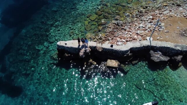 Friends standing on a pier in zavala, hvar island, croatia