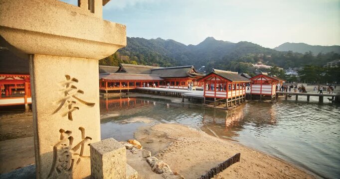 Steady Cam On Ancient Stone Lantern at Itsukushima Shrine In Miyajima Japan at Sunset