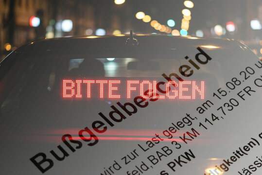 Schild Bitte Folgen an einem Zivilfahrzeug der Polizei und ein Bu&szlig;geldbescheid