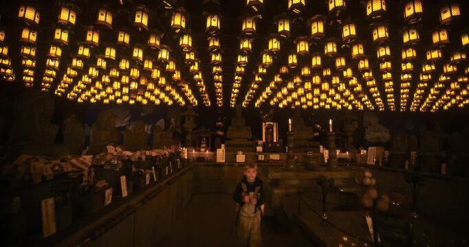 Hundreds of Hanging Lanterns Glow Inside Dark, Japanese Shrine As Boy Walks around - Steady Cam Shot