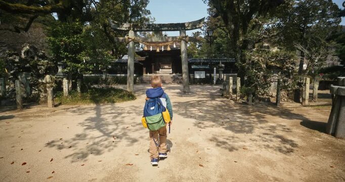 Child Walking Toward Torii Gate at Japanese Shinto Shrine, Wide Steady Cam Shot Following kid