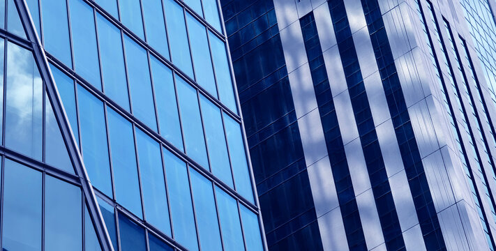 Urban skyscraper with mirrorlike surfaces showcasing clouds and geometric patterns