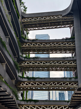 Concrete balconies rising in stark geometry, towering facade with deep shadows and rough texture