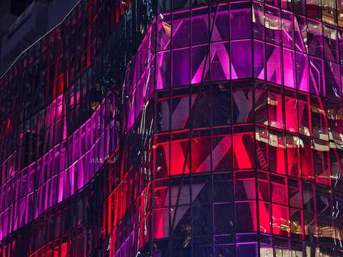 Cityscape illuminated by vivid neon reflections on stylish facades with tropical elements