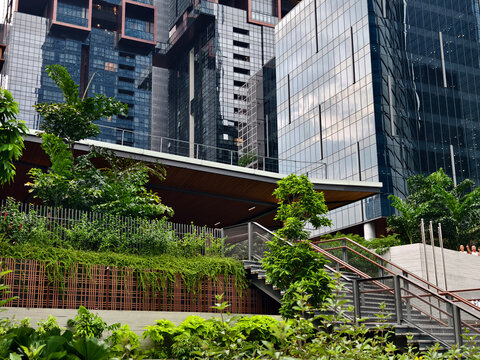 Contemporary urban architecture. Ecofriendly glass building nestled within urban garden setting