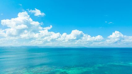 Fototapeta premium Tropical Nature clear sky and summer sea water under a clear blue sky with beautiful clouds and bright sunlight. Perfect for summer vacation and travel background 
