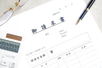 請求書 - 取引先へ宛てて請求書を準備する、ビジネスシーンのイメージ  © PJM
