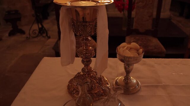 Consecrated bread and wine during a Catholic Mass, symbolizing the Holy Eucharist and the real presence of Christ in a sacred liturgical celebration.