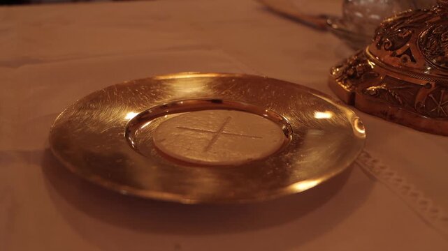 Consecrated bread and wine during a Catholic Mass, symbolizing the Holy Eucharist and the real presence of Christ in a sacred liturgical celebration.