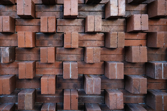 Decorative brick wall texture with protruding red clay bricks arranged in a geometric three-dimensional pattern. Ideal for architectural backgrounds, facade visuals, and contemporary exterior design.