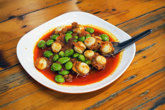 Spicy stir-fried twisted cluster bean (bitter bean or stink bean) with scallop, served with steamed jasmine rice, traditional Thai food recipe, popular in Southern Thailand.