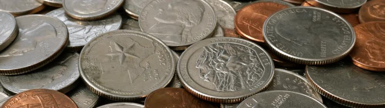 Various american currency coins including quarters dimes nickels and pennies representing savings wealth and transactions.
