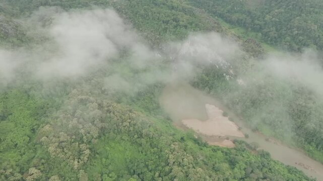 Drone footage flying over a winding river through a pristine tropical landscape in Laos